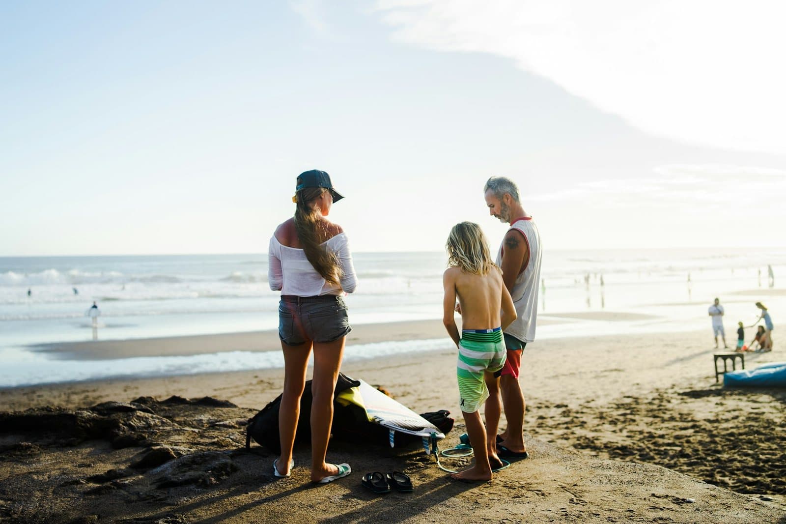 A beginner surf lesson gathering on the dark sand at Canggu, boards laid out on the beach